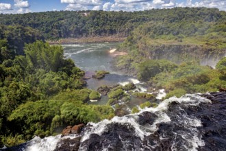 View along a cliff over a river with lush vegetation in the background, The Iguazu Falls between