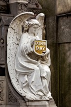 A sculpture of an angel holds a sign with an inscription, richly detailed, La Recoleta cemetery in