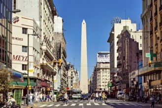 A busy street scene in daylight in Buenos Aires with the obelisk in the centre, The great obelisk