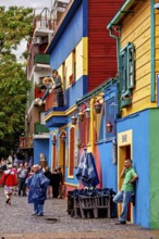 People stroll in front of colourful buildings with a dynamic, lively atmosphere, The colourful city
