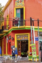 A lively pizza café with bright colours and balconies in a busy city street, the colourful city and