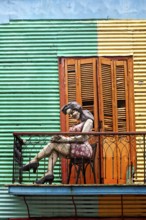 Female figure on a balcony in front of a striped façade, The colourful city and tango district of