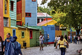 People stroll through a colourful street in a neighbourhood of colourful houses, The colourful city