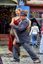 A couple happily dancing tango on a rain-soaked street in front of a café, The colourful city and