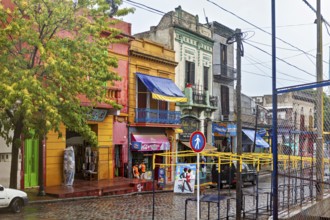 Lively street with colourful buildings and wet cobblestones on a cloudy day, The colourful city and