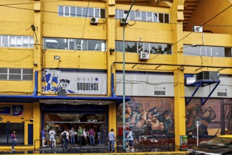 Entrance of the Museo Boquense with yellow and blue building, people in front of it, The football