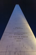 An illuminated obelisk with inscriptions in Buenos Aires at night against a deep blue sky, The