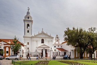 White church with bell tower and people in the forecourt in a quiet neighbourhood, La Recoleta