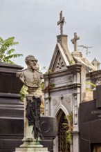 Monumental bust of a man in a cemetery, surrounded by historic tombs, La Recoleta Cemetery in