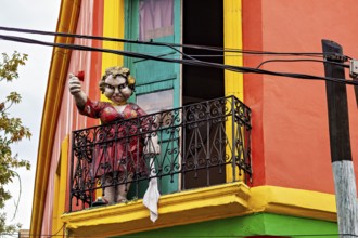 Sculpture of a child with a balloon on a balcony in a colourful house, The colourful city and tango