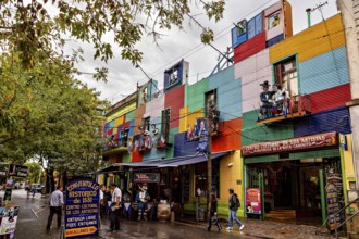 A colourful façade full of artists and shops attracts people despite the rain clouds, The colourful