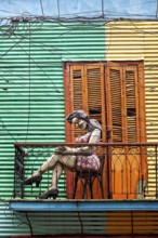 Colourful façade with sculpture of a woman on a small balcony, The colourful city and tango