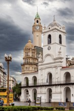 Centrally located colonial-style buildings with prominent clock towers and clouds in the sky,