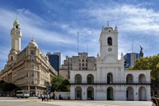 Historic white buildings with a clock tower, busy street and blue sky with few clouds, The city of