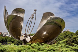 Modern sculptural flower surrounded by vegetation, with elements representing the pistil, The lotus