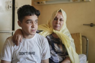 Wounded individuals receiving treatment at a hospital after being evacuated with difficulty from
