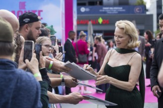 Pamela Anderson signs autographs in front of the film premiere of The Naked Gun at UCI Luxe East