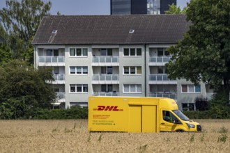 DHL parcel van, electric vehicle, on the way to a customer, rural, driving along a dirt track