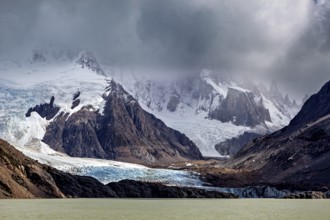 Dramatic glacier with rocks and threatening clouds form an impressive backdrop, The Perito Moreno