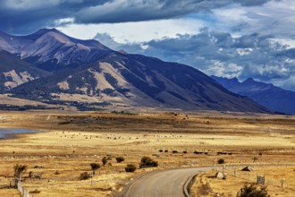 Wide plains with a winding road and a majestic mountain range in the background, the Patagonian