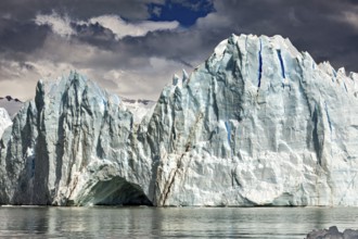 Majestic glacier front under a cloudy sky with mountains in the background, The glacier of Perito