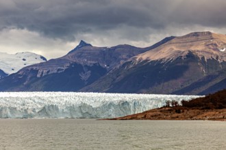 Impressive glacier front with dramatic sky and mountainous backdrop, The Perito Moreno glacier in