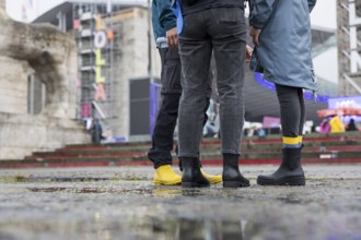 Festival visitors with rubber boots in front of the Olympic Stadium at the Lollapalooza Festival in
