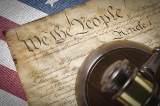 United states constitution, gavel and american flag resting on table