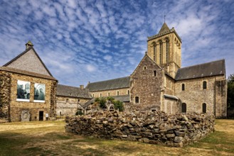 A church with adjoining ruins and stone walls under a blue sky, The Abbey de La Lucerne in