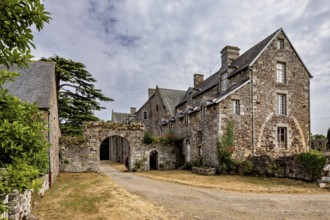 Historic stone building with an archway under a cloudy sky in a rural setting, The Abbey de La