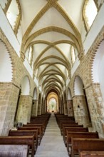 Interior view of a Gothic church with impressive arches and wooden rows of seats, The Abbey de La