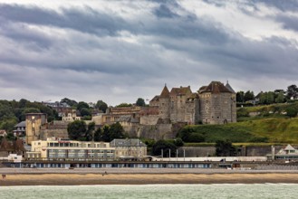 Medieval castle with surrounding town on the beach, under a cloudy sky, historical ambience, Dieppe