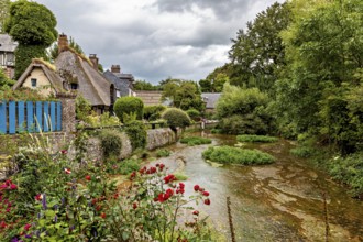 Picturesque landscape with a river and flowering gardens in a village, the historic mill village of