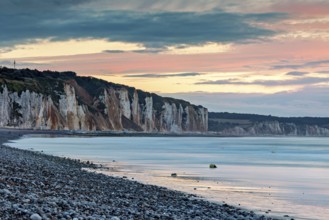 Dramatic cliff landscape with gentle sea coast at sunset with atmospheric sky, The cliffs near