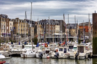 Lively harbour with numerous sailing and motor boats against a backdrop of historic buildings, the