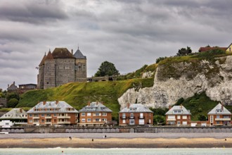 Castle on cliffs above modern buildings, cloudy sky, historic architecture by the sea, Dieppe