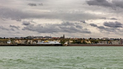 Coastal town with cliffs and a church, under a cloudy sky, The coast of Dieppe in Normandy, France