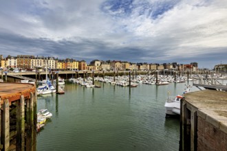 View of a harbour with many boats and historic buildings under a dramatic sky, The harbour of