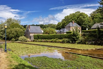 Sprawling fields with brick houses under a blue sky, surrounded by green nature, the historic mill