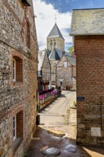 Idyllic village alley with pictures of the church and old brick houses in the sunshine, The