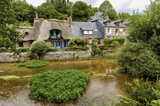 Idyllic river landscape with half-timbered house and lush gardens in the background, the historic