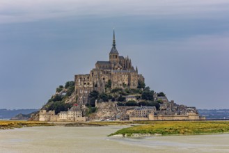 A castle on an island in a river, against a greying sky, Mont Saint Michel in Normandy, France