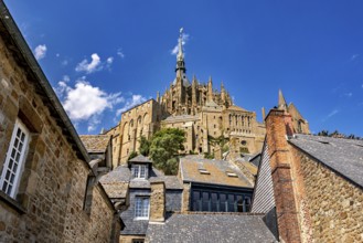 Sublime castle with Gothic towers, rising into the sky above the roofs of historic buildings, Mont