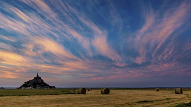 Mont Saint-Michel at sunset with dramatic sky and straw bales, Mont Saint Michel in Normandy,