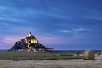 Mont Saint-Michel at dusk, illuminated with straw bales in the foreground, Mont Saint Michel in