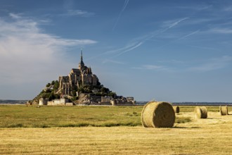 Landscape with Mont Saint-Michel and straw bales under a bright blue sky, Mont Saint Michel in