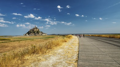 The monastery of Mont Saint-Michel in the distance under a clear sky and slightly cloudy, Mont