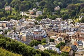 Expansive view of a town from a green hill with lots of nature, Etretat in Normandy, France