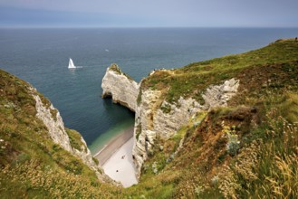 Green cliffs with sailing boat in the sea and small beach bay, The cliffs and alabaster coast of