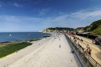 Wide beach with sea view and people walking under a blue sky, Etretat in Normandy, France